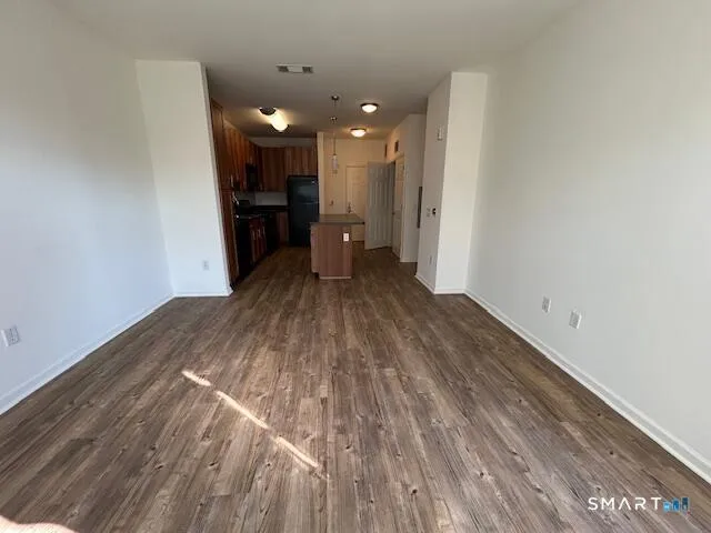 a view of empty room with wooden floor