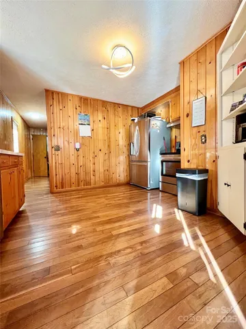 a view of a large kitchen with wooden floor and furniture