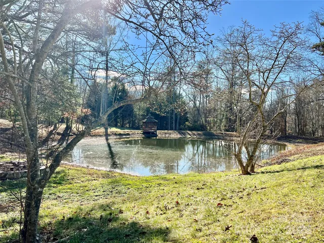 a backyard of a house with large trees and wooden fence