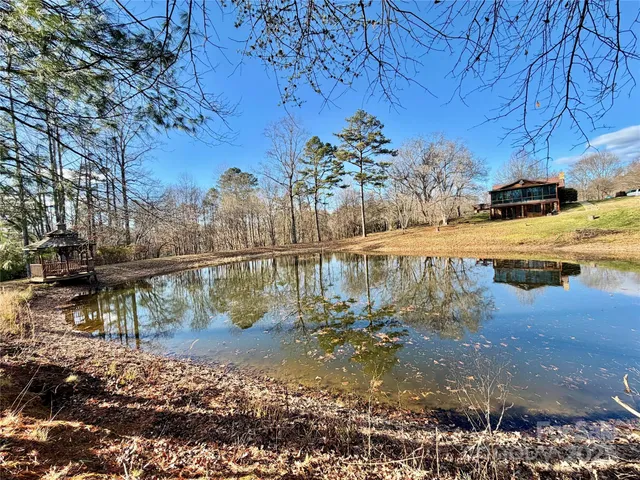 a view of a lake with a lawn chairs under an umbrella