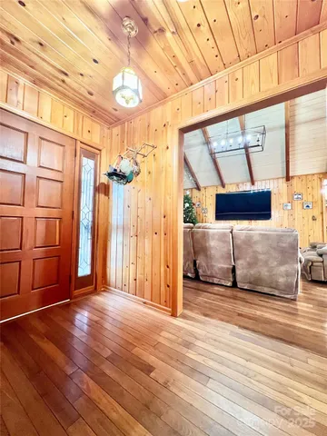 a view of a hallway with wooden floor and door