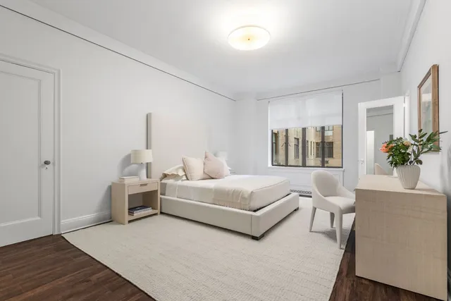 a living room with furniture and a potted plant next to a window