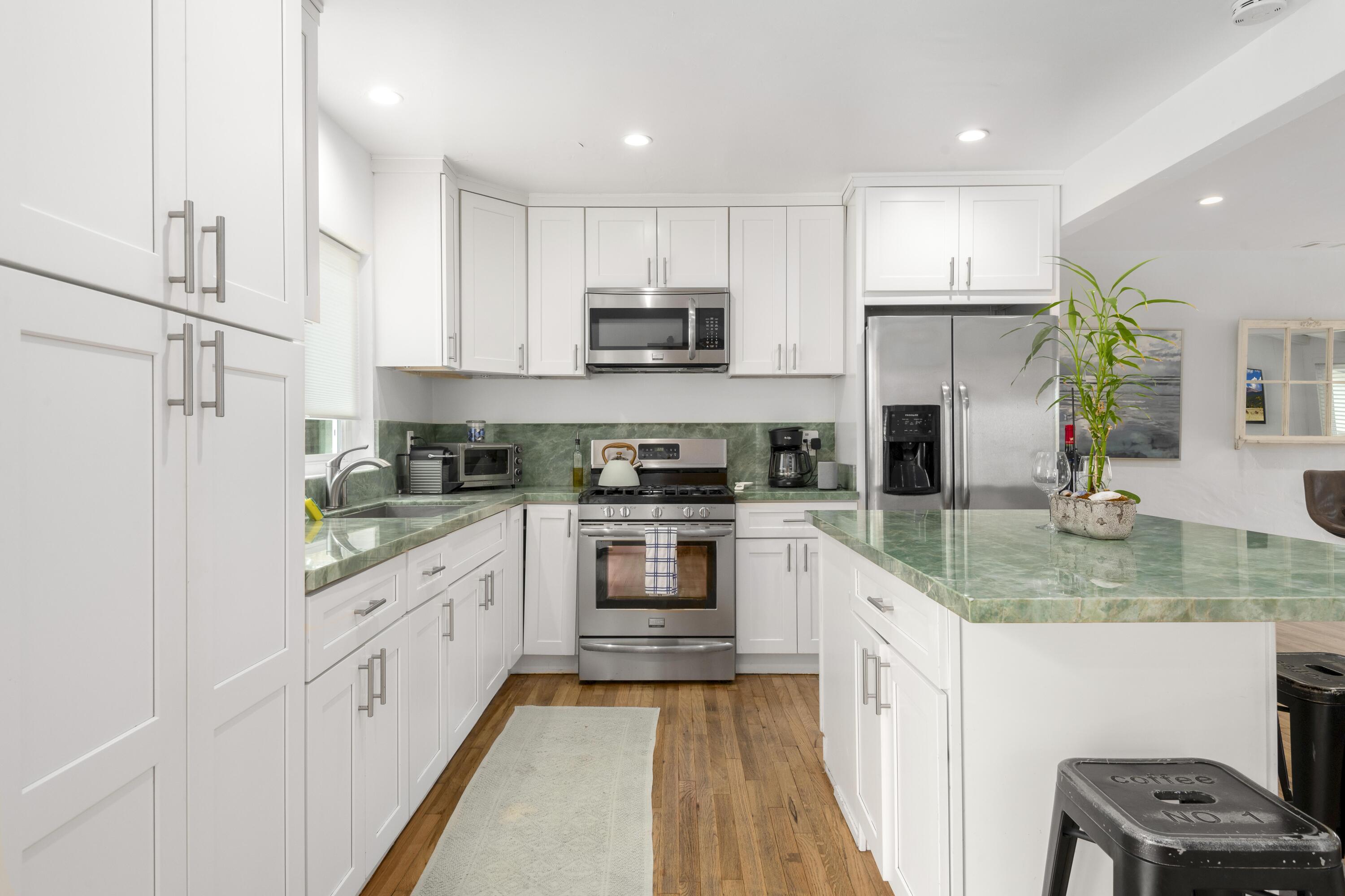 1102 Del Mar Avenue Santa Barbara, CA 93109 - Photo 10 of 39 a kitchen with granite countertop a refrigerator sink and white cabinets