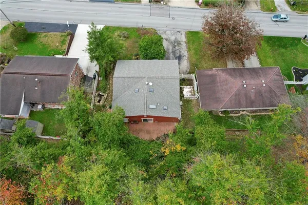 an aerial view of residential houses with outdoor space and trees