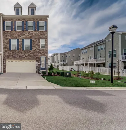 a front view of a house with a garden and plants