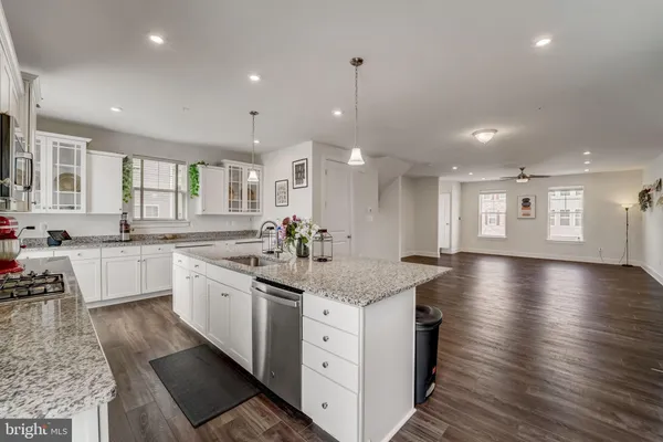 a kitchen with stainless steel appliances granite countertop a sink a stove top oven a counter space and cabinets