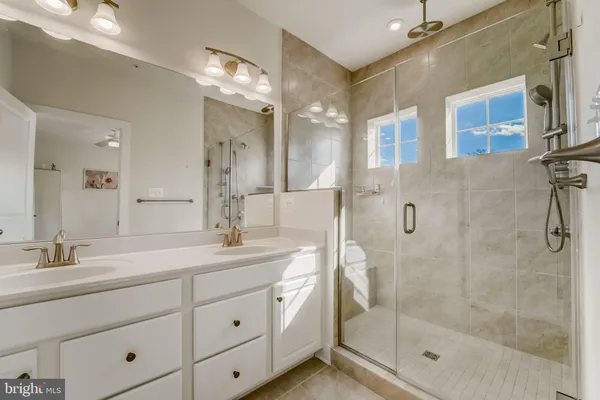 a bathroom with a shower sink and mirror