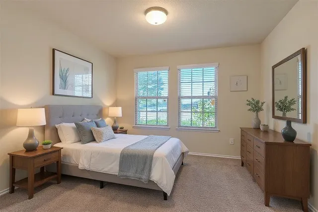 a bedroom with a bed a dresser and chair