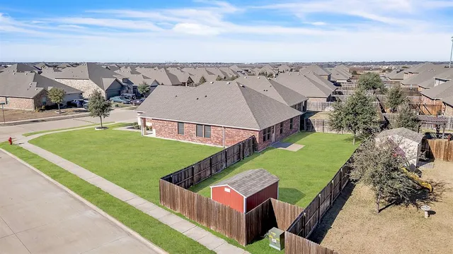 an aerial view of a house with a garden and lake view