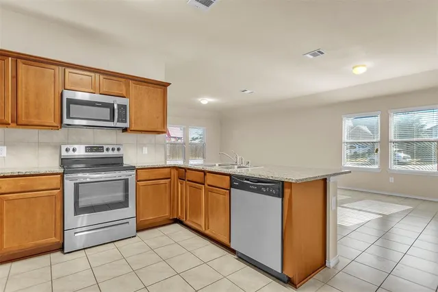a kitchen with stainless steel appliances granite countertop a stove a sink and a microwave