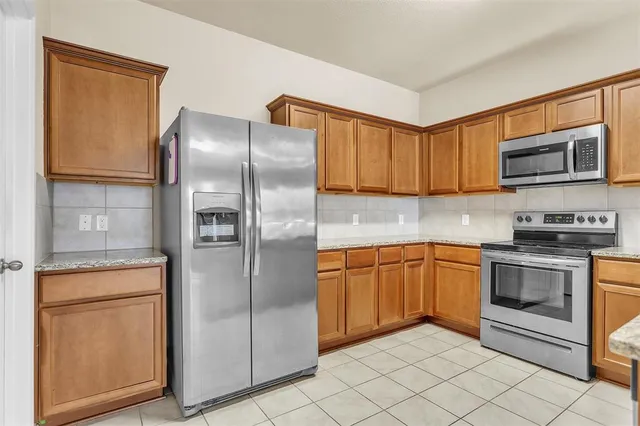 a kitchen with stainless steel appliances granite countertop a refrigerator sink and microwave