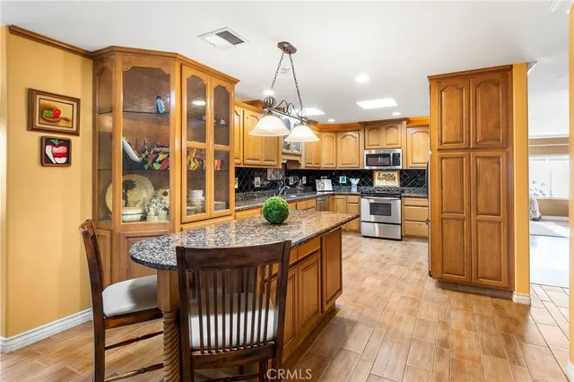 a kitchen with stainless steel appliances granite countertop a sink a stove and a refrigerator