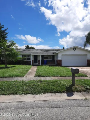 a front view of house with yard and green space