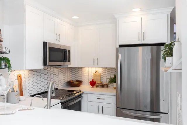 a kitchen with stainless steel appliances a refrigerator sink and microwave