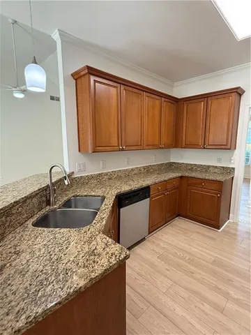 a kitchen with granite countertop a sink a stove and cabinets
