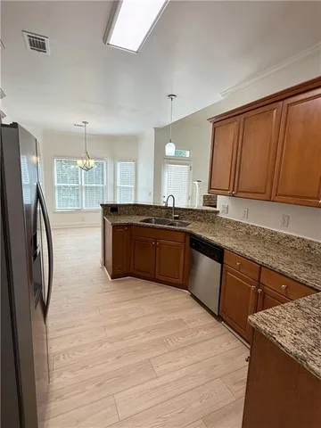 a kitchen with stainless steel appliances granite countertop a refrigerator and a sink