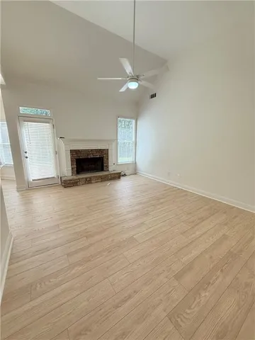 a view of empty room with wooden floor and fireplace