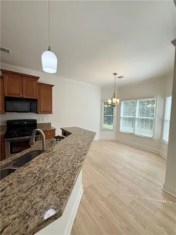a kitchen with stainless steel appliances granite countertop a stove oven and a wooden cabinets