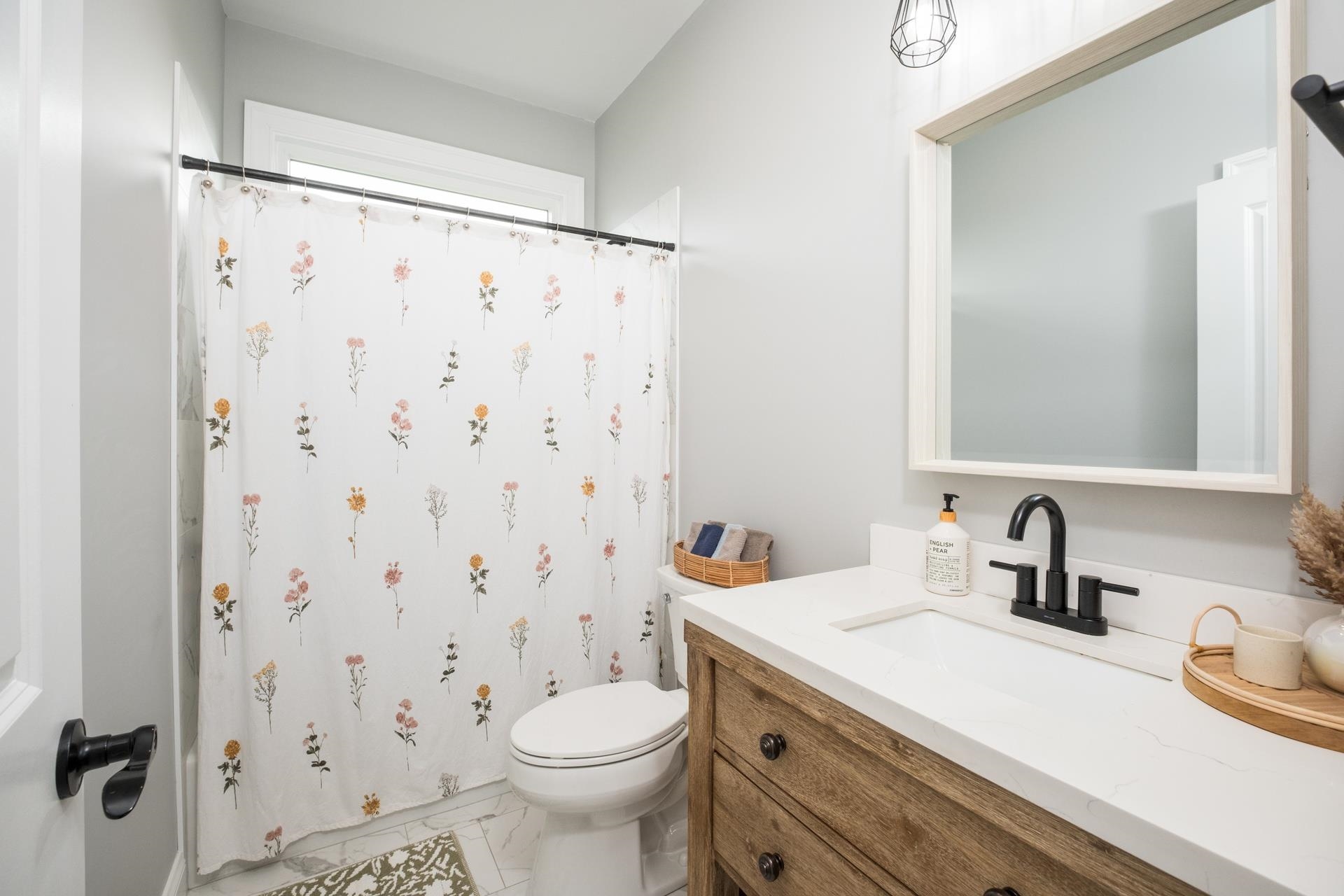303 Bartley Street Dayton, VA 22821 - Photo 30 of 47 a bathroom with a sink toilet a mirror and shower curtain
