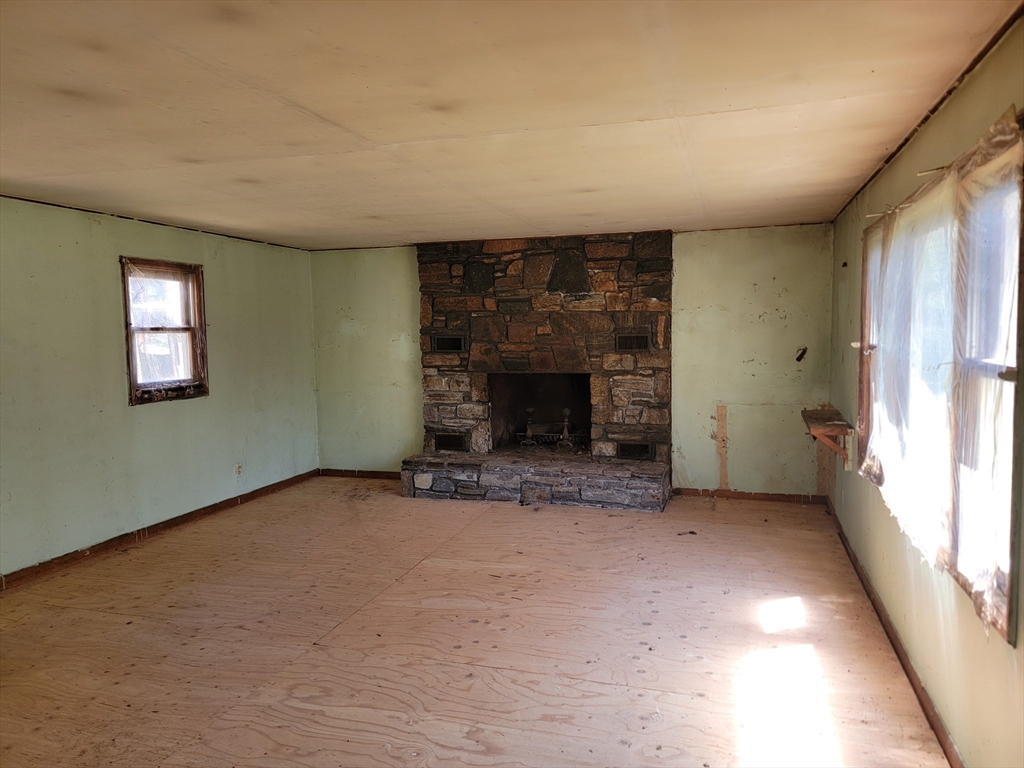 10 Moss Brook Road Orange, MA 01364 - Photo 3 of 8 an empty room with a fireplace and window