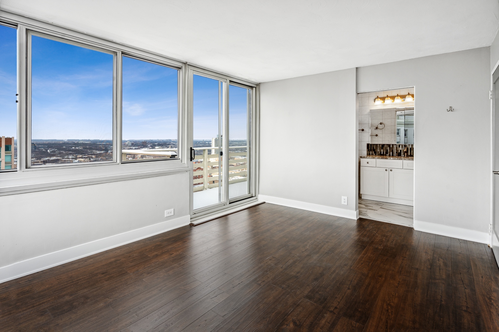 5601 North Sheridan Road, Unit 21E Chicago, IL 60660 - Photo 12 of 27 an empty room with wooden floor and windows