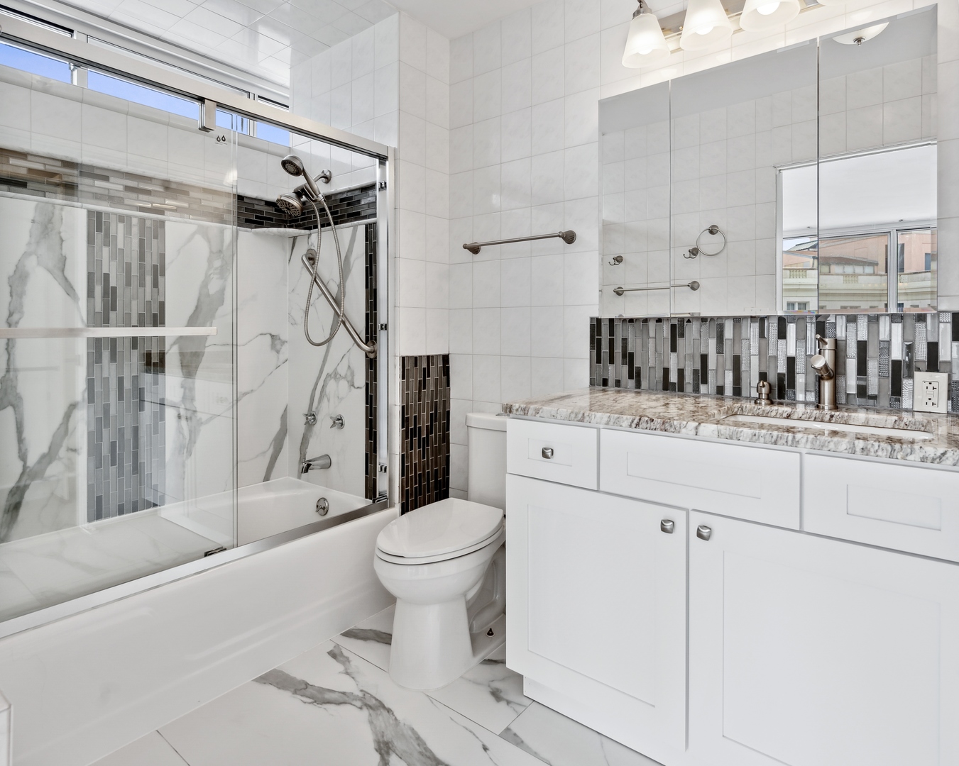 5601 North Sheridan Road, Unit 21E Chicago, IL 60660 - Photo 13 of 27 a bathroom with a sink toilet and shower