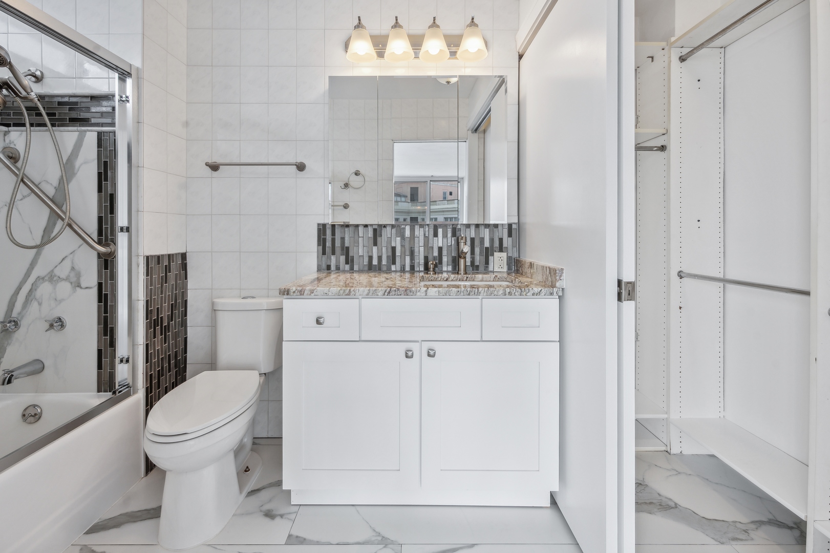 5601 North Sheridan Road, Unit 21E Chicago, IL 60660 - Photo 14 of 27 a bathroom with a sink a toilet and shower