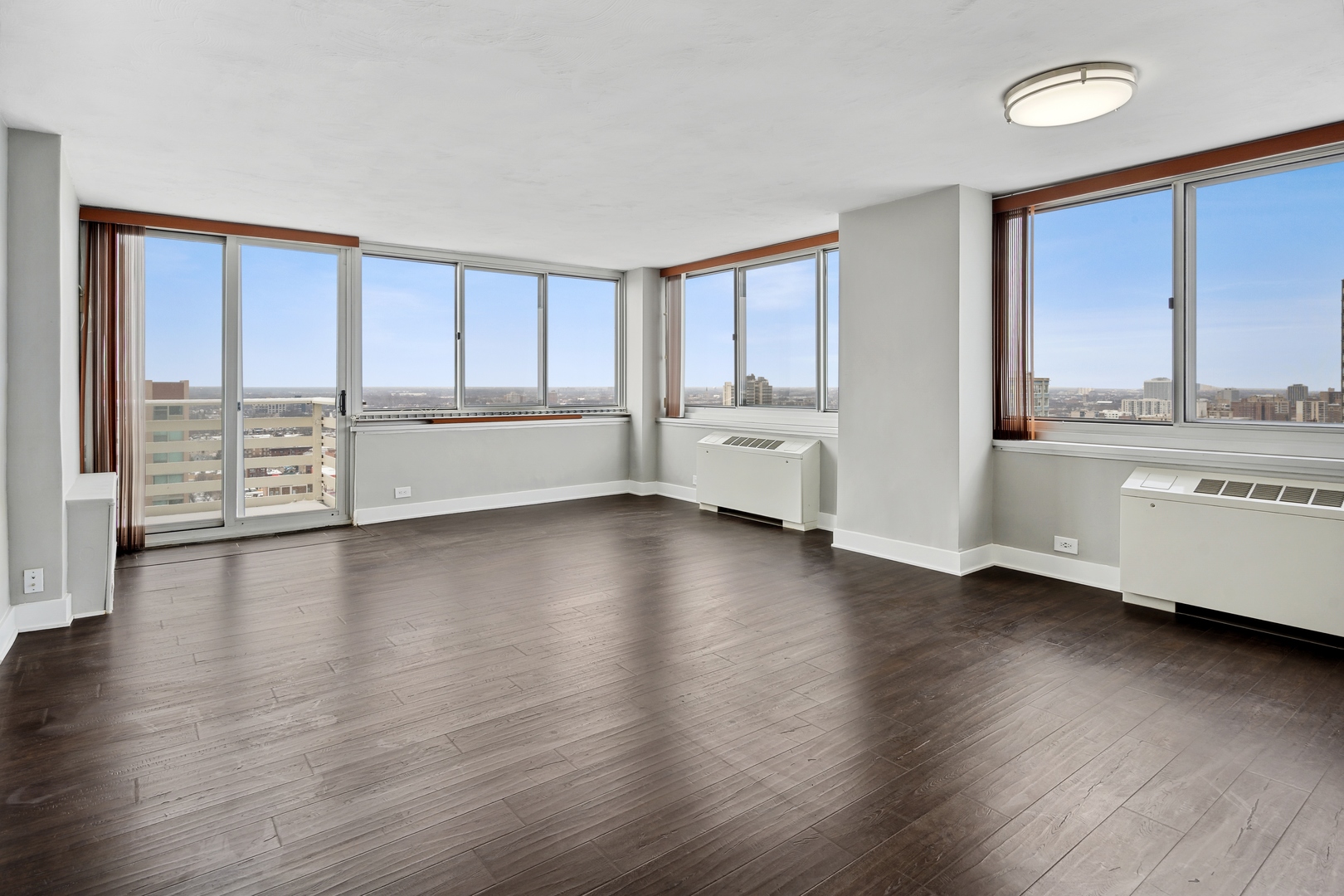 5601 North Sheridan Road, Unit 21E Chicago, IL 60660 - Photo 3 of 27 a large living room with hard wood floors and a window
