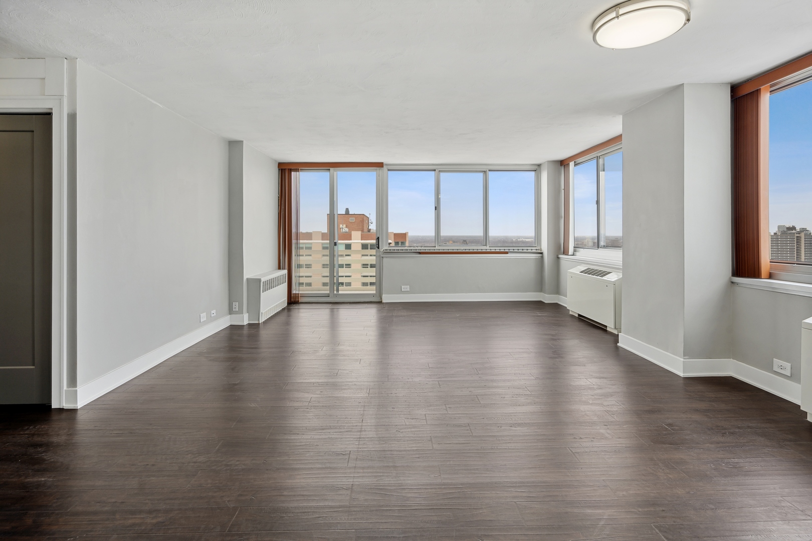 5601 North Sheridan Road, Unit 21E Chicago, IL 60660 - Photo 4 of 27 a view of an empty room with window and wooden floor