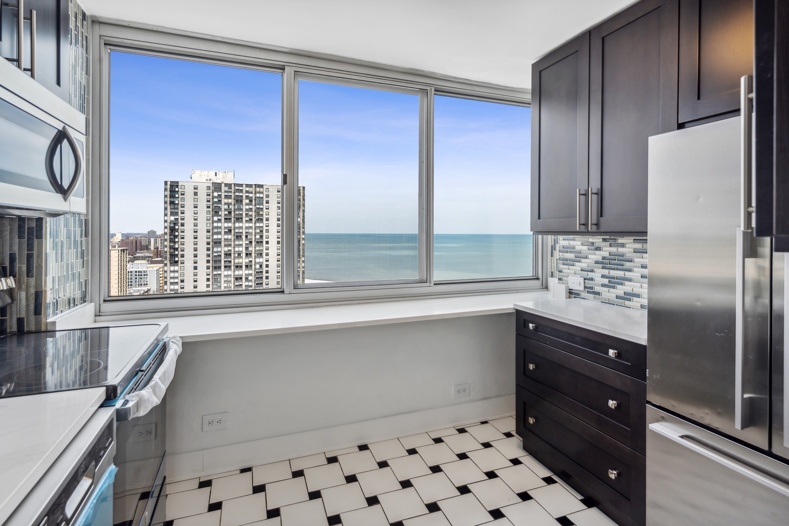 5601 North Sheridan Road, Unit 21E Chicago, IL 60660 - Photo 7 of 27 a kitchen with a refrigerator a sink and cabinets