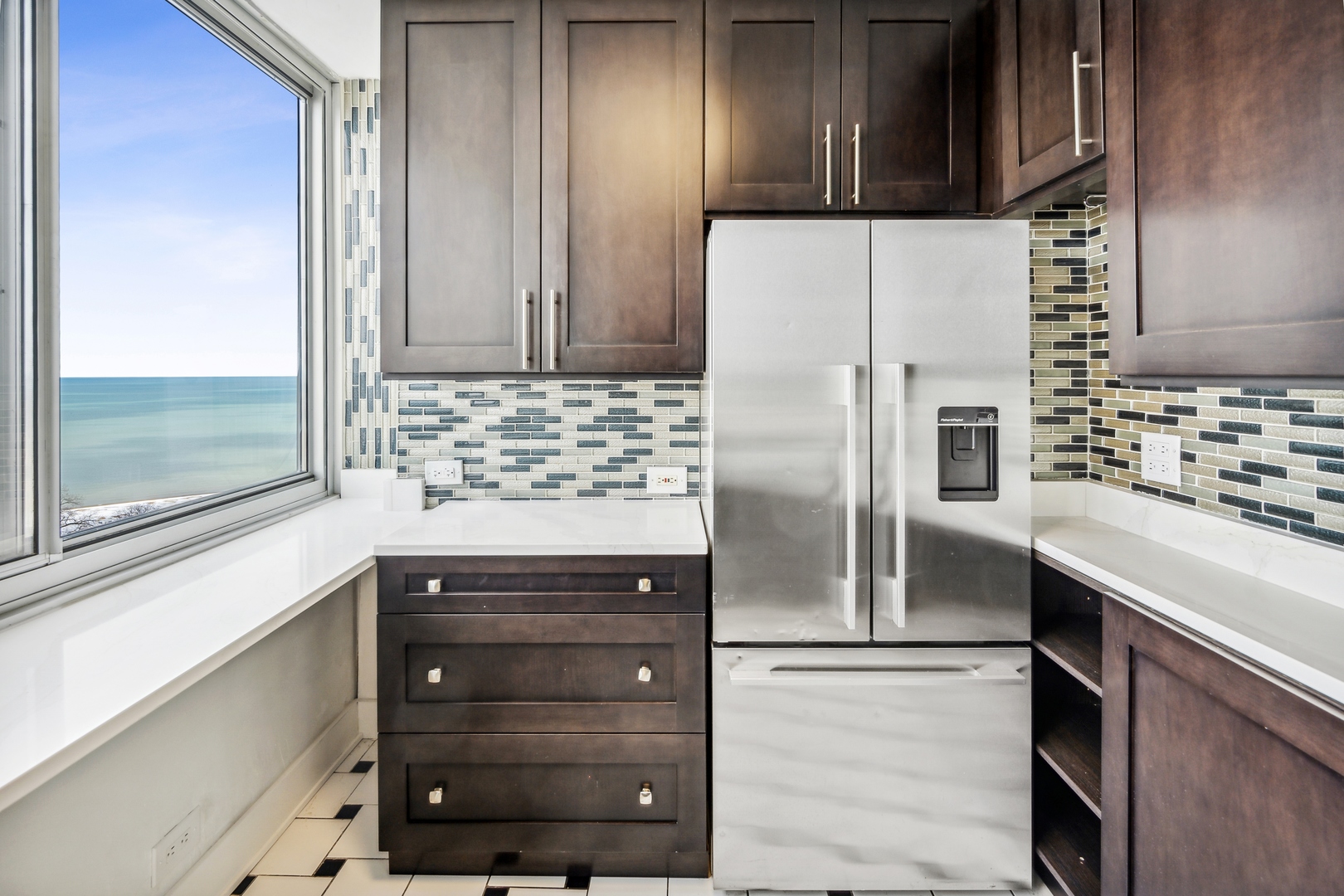 5601 North Sheridan Road, Unit 21E Chicago, IL 60660 - Photo 10 of 27 a kitchen with granite countertop stainless steel appliances and wooden cabinets