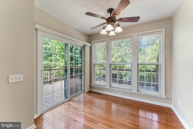 a view of a livingroom with wooden floor and a large window