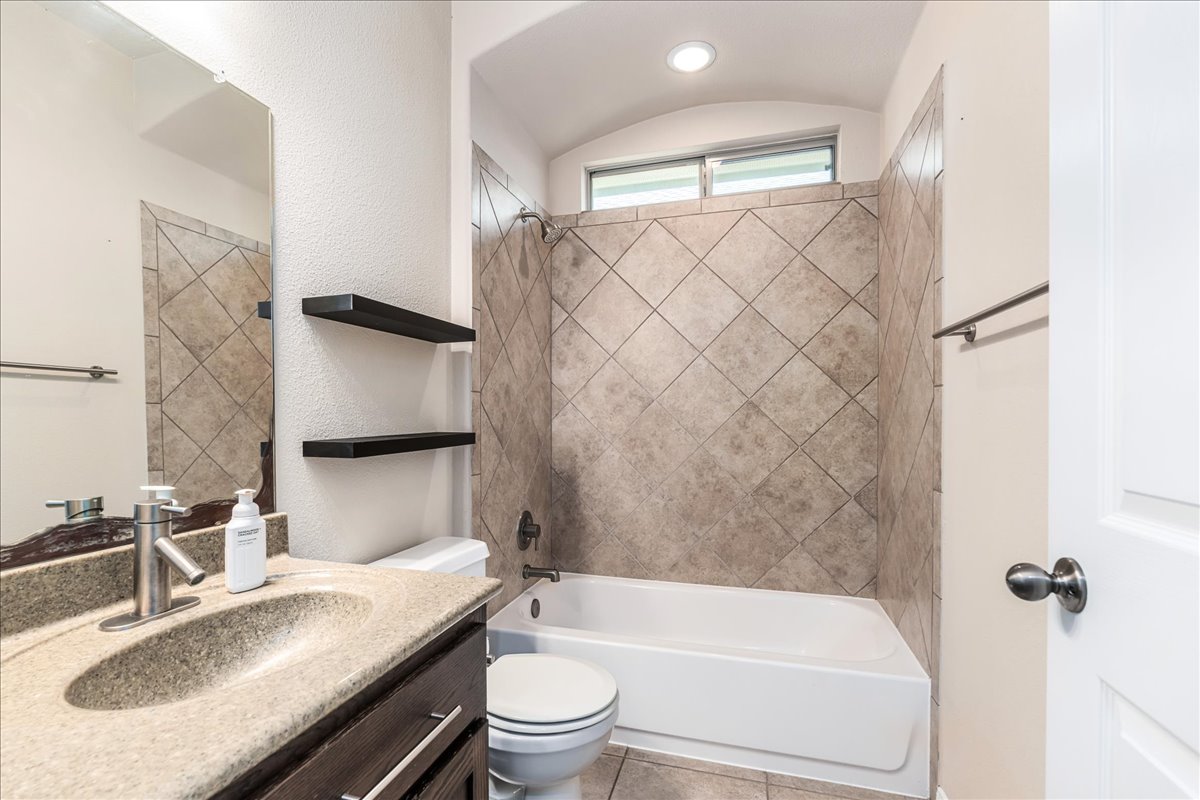 137 Navigator Drive Austin, TX 78717 - Photo 14 of 18 a bathroom with a granite countertop sink toilet and shower