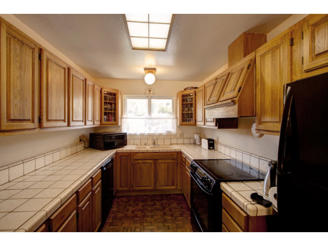 2995 Ribera Road Carmel, CA 93923 - Photo 8 of 16 a kitchen with a sink a stove cabinets and a wooden floor
