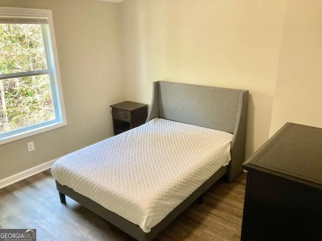 a large bed sitting in a bedroom next to a window