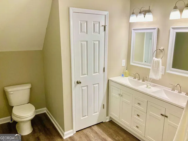 a bathroom with a toilet sink and mirror