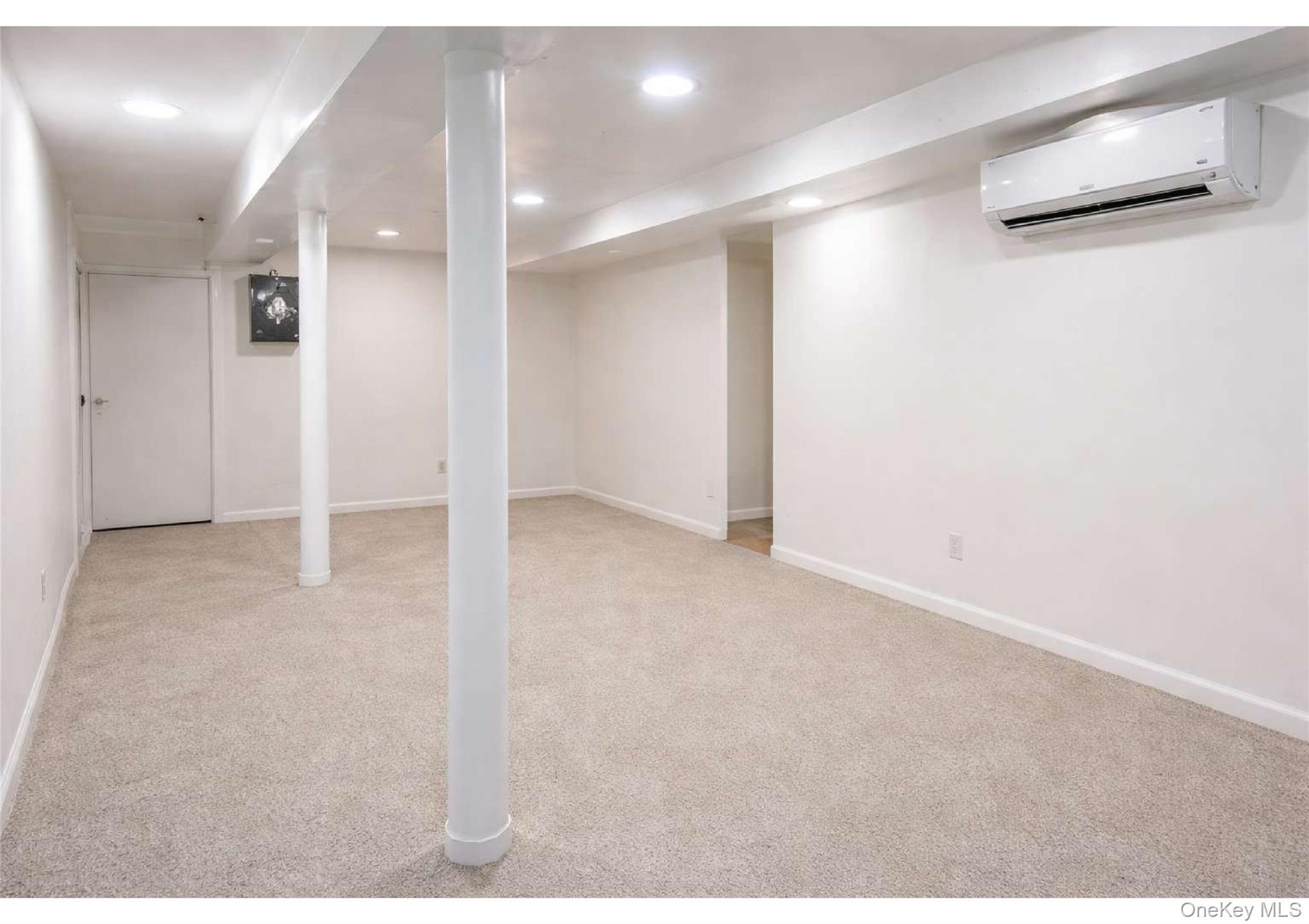 85-40 79th Street Queens, NY 11421 - Photo 13 of 19 Finished below grade area featuring a wall unit AC, light carpet, and recessed lighting