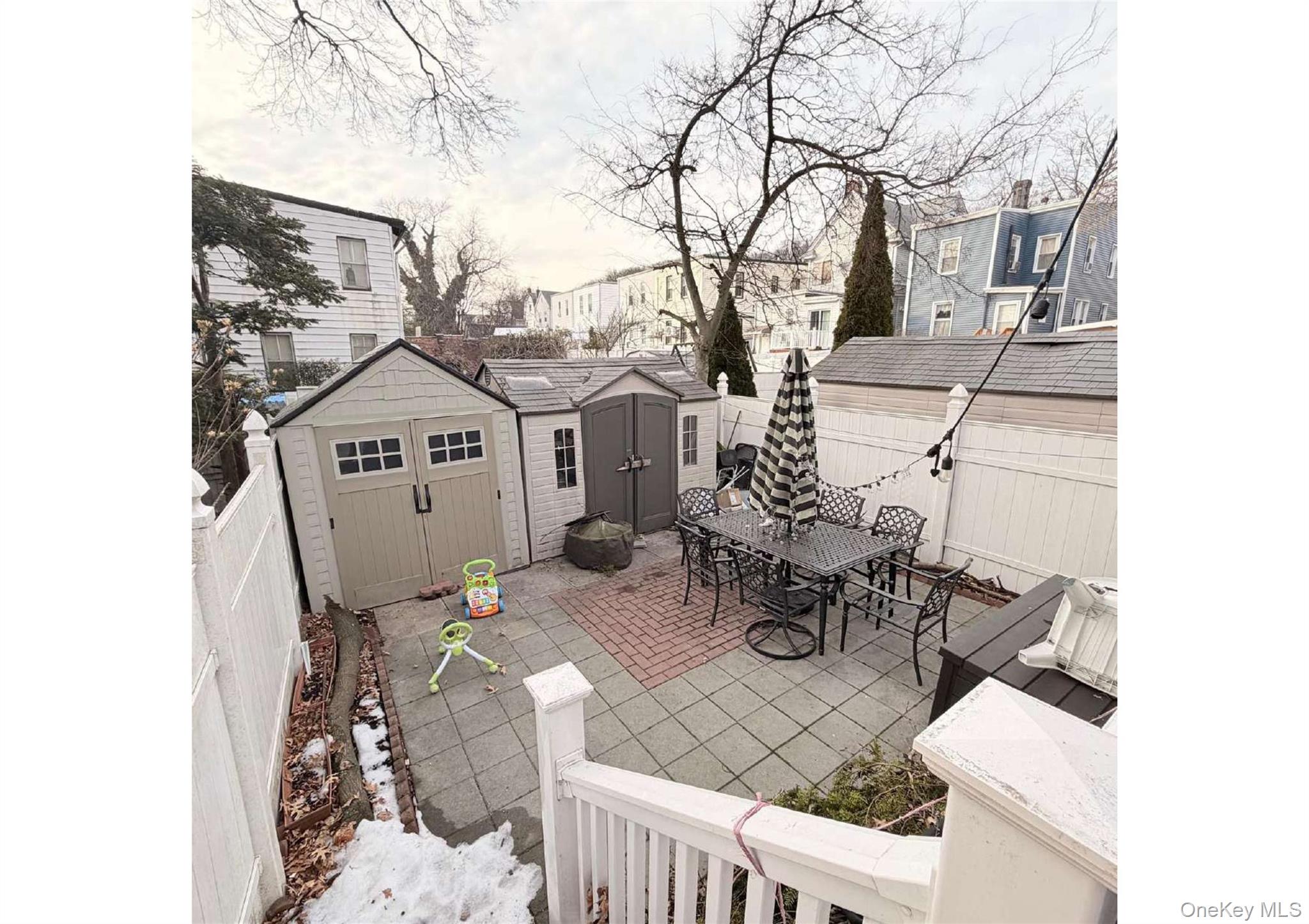 85-40 79th Street Queens, NY 11421 - Photo 15 of 19 Fenced backyard with outdoor dining space, a storage unit, and a patio area