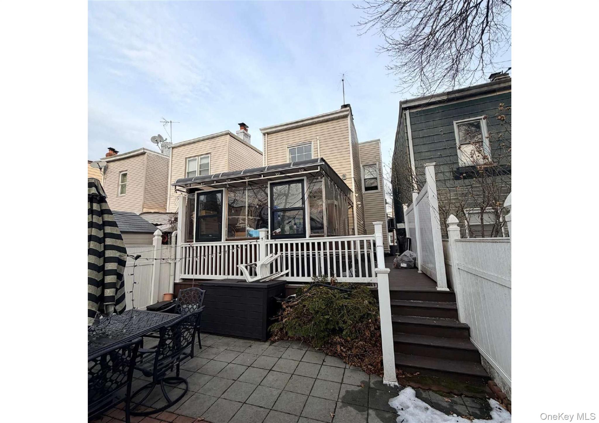 85-40 79th Street Queens, NY 11421 - Photo 2 of 19 Back of house featuring a sunroom and a wooden deck