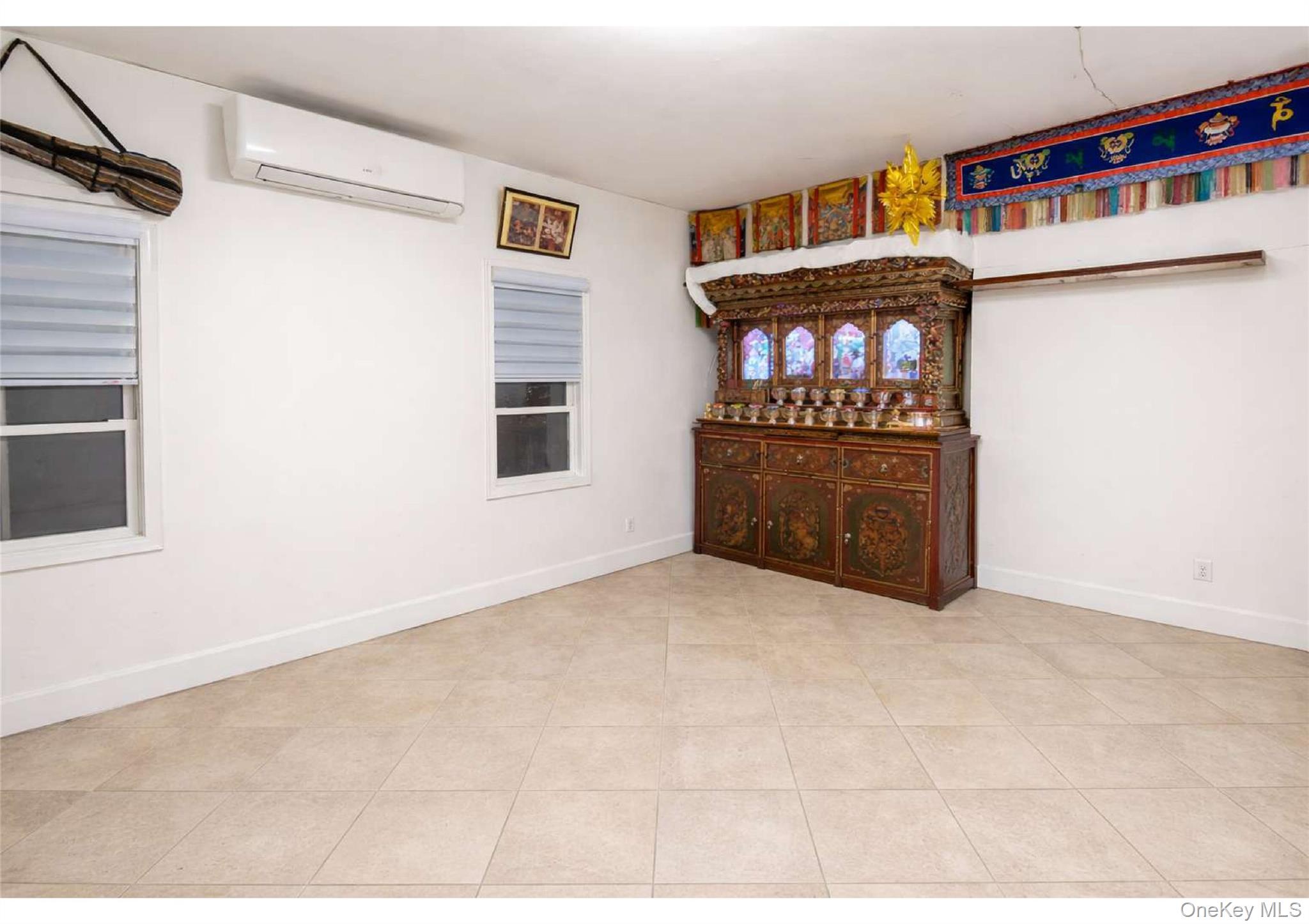 85-40 79th Street Queens, NY 11421 - Photo 5 of 19 Spare room featuring an AC wall unit and light tile patterned floors