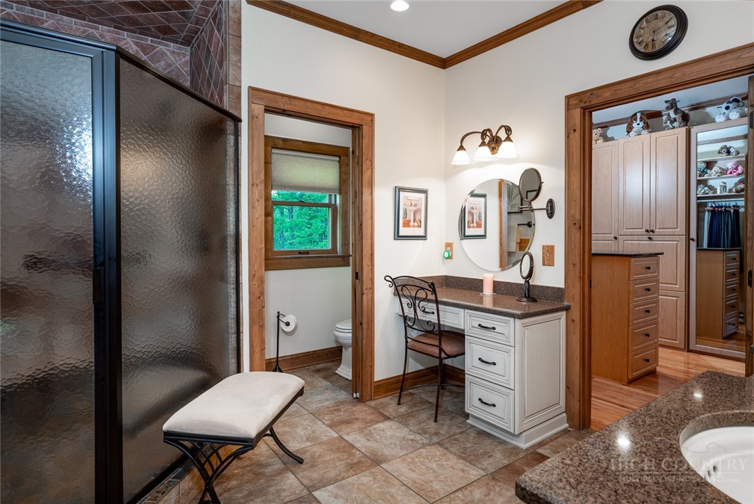 171 Camp Davis Road Banner Elk, NC 28604 - Photo 21 of 48 a spacious bathroom with a granite countertop sink a toilet a mirror and vanity