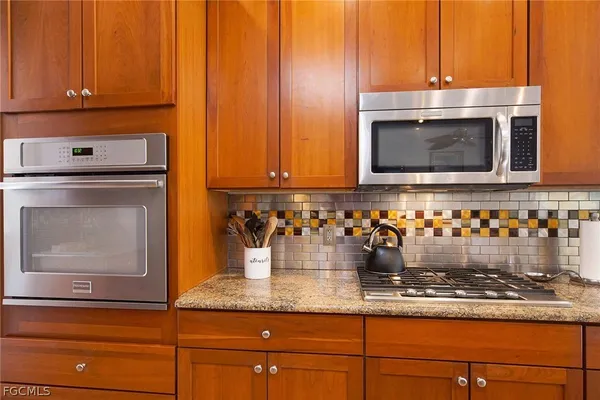 a kitchen with granite countertop cabinets and steel stainless steel appliances