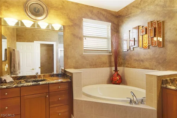 a bathroom with a tub sink and mirror