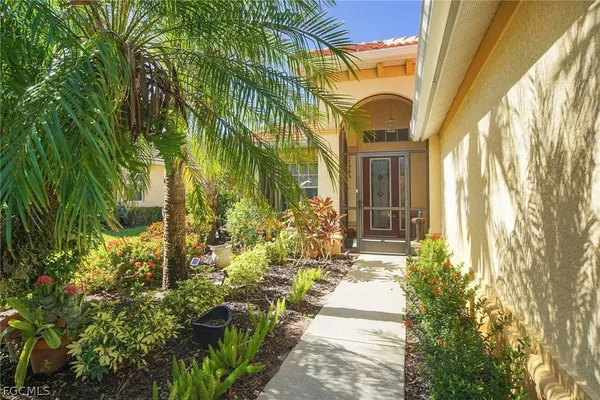 a view of a house with a large window and potted plants
