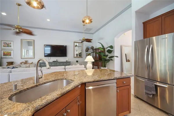 a kitchen with stainless steel appliances granite countertop a sink a refrigerator and a granite counter tops