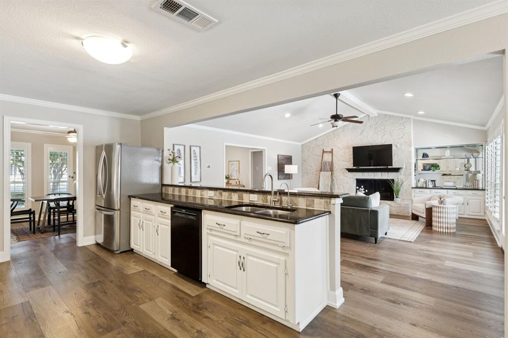 14420 Overview Drive Dallas, TX 75254 - Photo 8 of 35 a kitchen with stainless steel appliances kitchen island granite countertop a stove top oven a sink dishwasher a dining table and chairs with wooden floor