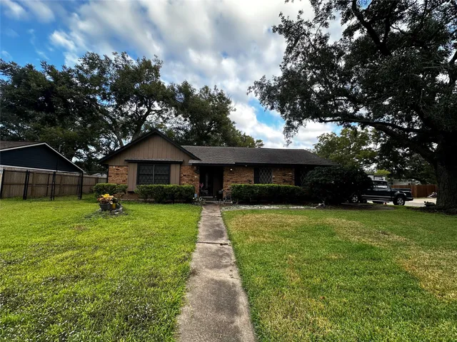 a front view of a house with a yard and trees