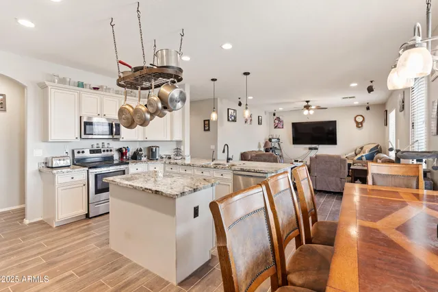 a kitchen with stainless steel appliances kitchen island a large island in the center and cabinets