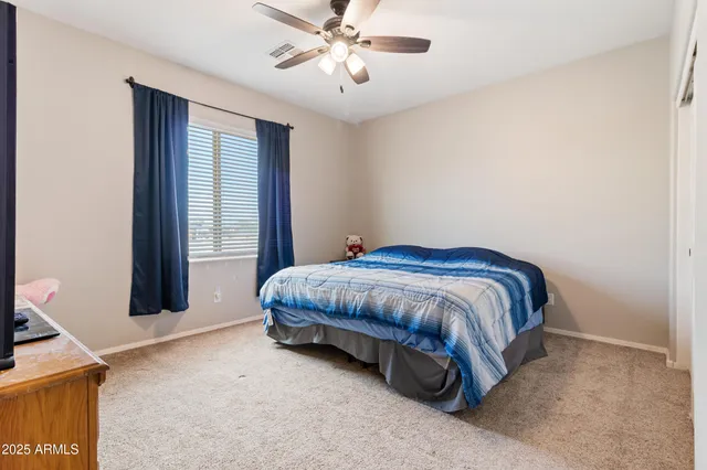 a spacious bedroom with a bed and a chandelier