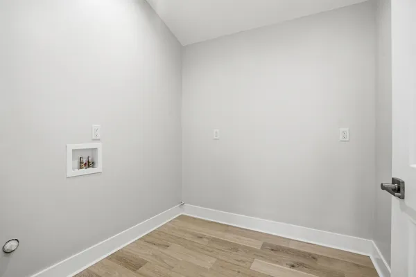 a view of a small space with wooden floor and a window